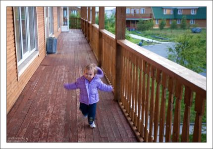 Саша бегает по веранде гостиницы "Причал". Кемский район республики Карелия, Россия.