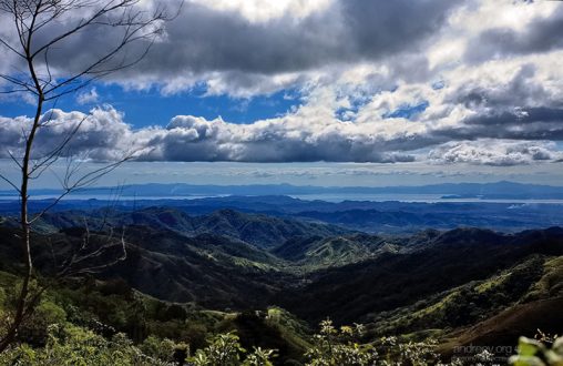 Дождевые облака над холмами, и озеро Аренал на заднем плане.