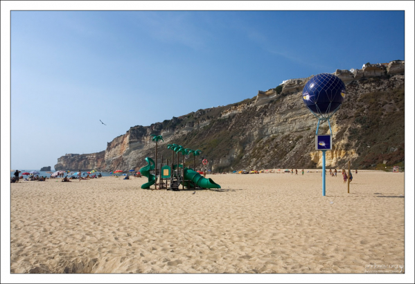 Пляж под скалой.