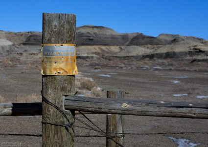 Забор с колючей проволокой по периметру пустоши.