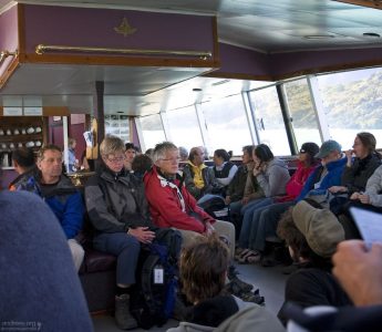 Уставшие туристы на пароме через озеро Pehoe.