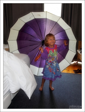 Саша в фиолетовом платье с фиолетовым зонтиком в гостинице.