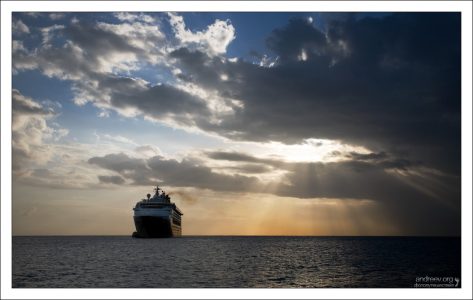 Круизное судно "Mariner of the Seas" у берегов острова на закате.