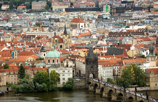 Карлов мост с толпами туристов. Красные крыши постепенно сдают позиции серым и белым.