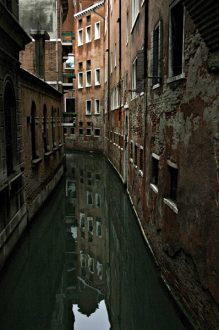 Отражения домов в спокойных водах канала.