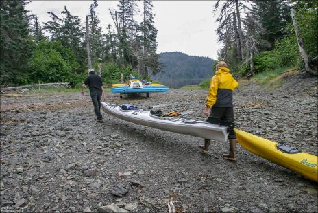 Илья и Рон перетаскивают каяки через насыпь.