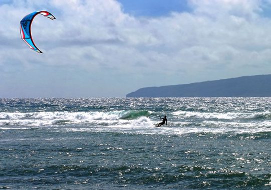 Серфинг с воздушным змеем в сверкающих водах Гавайев.