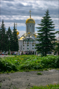 Люди, пришедшие за святой водой. Сверху над крестом воздвигнут изящный шатер с куполом и крестом. Троице-Сергиева Лавра.