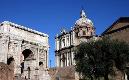 Триумфальная арка Септимиуса Северуса и Курия (здание древнеримского сената). Римский форум.