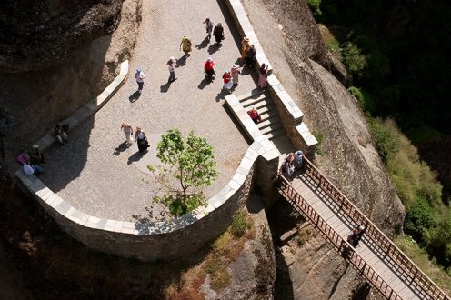 Туристы над пропастью у мостика, ведущего в монастырь Варлаама. Метеоры.