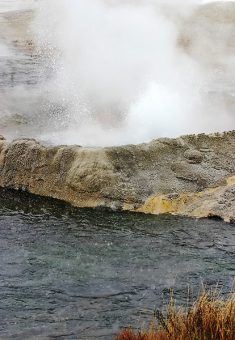 Небольшой гейзер на берегу реки. Biscuit basin.