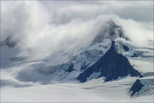 Снежная дымка над нунатаком (изолированной скалой, окруженной льдом со всех сторон).