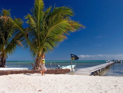 Пирс, вдающийся в зеленые воды Карибского моря.