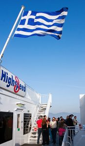 Пассажиры парома и греческий флаг.