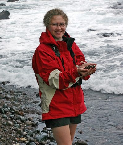 Катя с красным песком в руках.