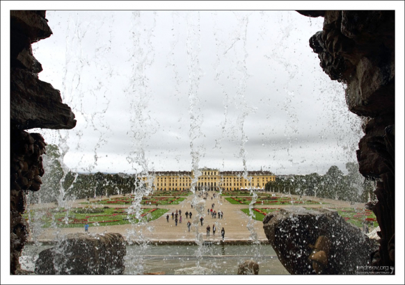 Дворец Schönbrunn через струи фонтана "Нептун".