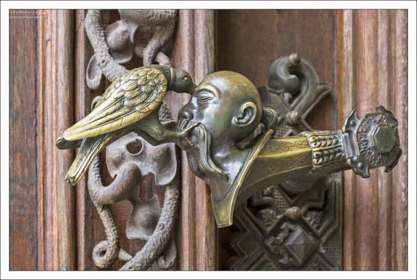 Дверная ручка: голова турка, и клюющий её ворон.