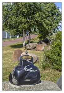 Кошелек удачи - камень естественной формы, подаренный городу строительной компанией из Риги. На металлической защелке надпись: "Жителям Петрозаводска. Будьте счастливы и богаты!".