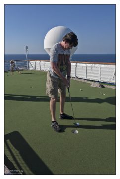 Илья и Саша играют в мини-гольф.