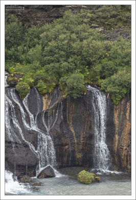 Застывший поток лавы и протекающий сквозь него водопад.
