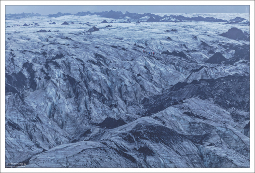 Еле видимая цепочка людей потерялась среди массы ледника.