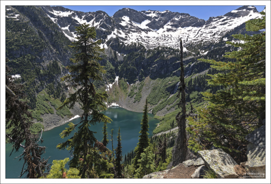 Среди деревьев проглядывает Rainy Lake (Дождевое озеро).