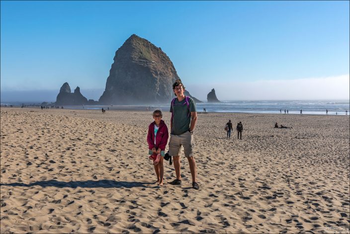 Илья и Саша на фоне скалы Haystack Rock на пляже Cannon beach.