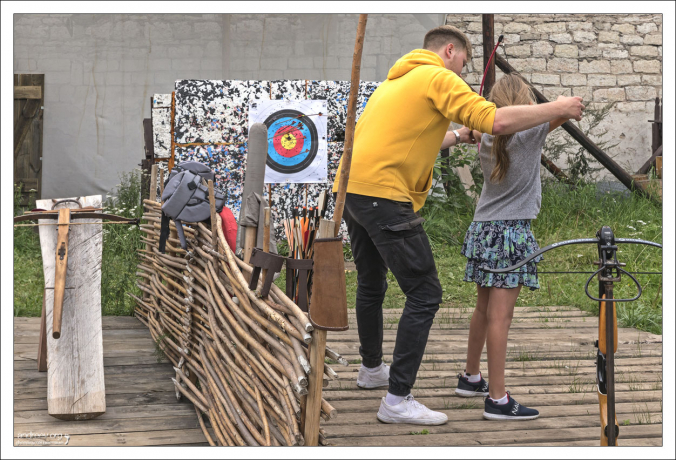 Саша учится стрелять из лука.