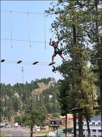 Сложная часть из подвесных мостов между деревьев в веревочном парке Aerial Adventure Park.