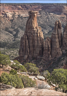 Изолированные скальные столбы и башни с вертикальными обрывистыми сторонами находятся в каньоне Монумент ниже Rim Rock Drive.