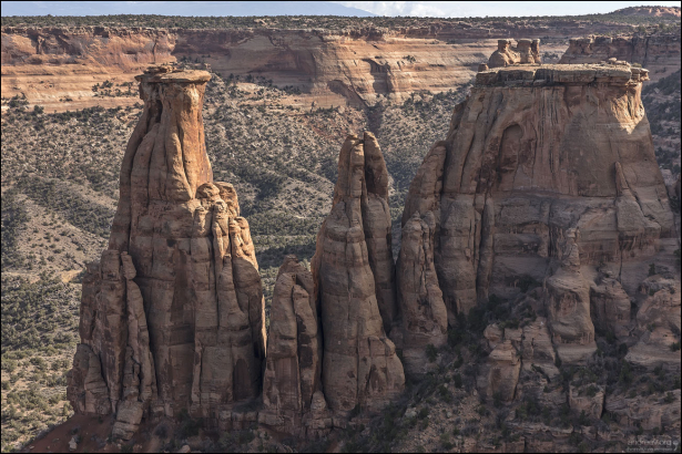 Шпили и монолиты из песчаника Уингейт с тонкой шапкой формации Кайента в каньоне Monument Canyon.