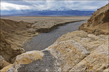 Каньон с узкими проходами, песчаными склонами и размытыми глиняными стенами.
