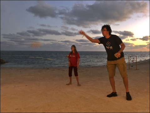 Игра Cornhole на пляже. Игроки бросают мешочки с кукурузными зернами или пластиковыми гранулами на наклонную деревянную доску с круглым отверстием.
Цель – попасть в лунку или задержать мешочек на доске.
Cornhole особенно популярен в США, особенно на фестивалях, спортивных мероприятиях и семейных встречах.