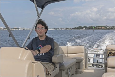 Илья за рулем понтонной лодки.