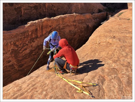 Гид Джейк проверяет Сашины обвязки перед раппелингом.