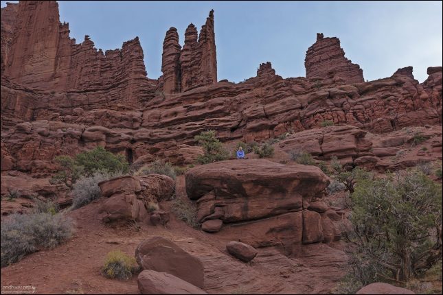 Башни возвышаются как гигантские "пальцы" или шпили на фоне пустынного плато.