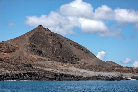 Остров Бартоломе расположен у восточного побережья острова Сантьяго, в заливе Sullivan Bay. Это вулканический остров, сформированный серией извержений около 100–150 тысяч лет назад — по геологическим меркам, почти «вчера».