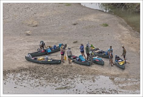 Группа туристов на каноэ готовится к сплаву.