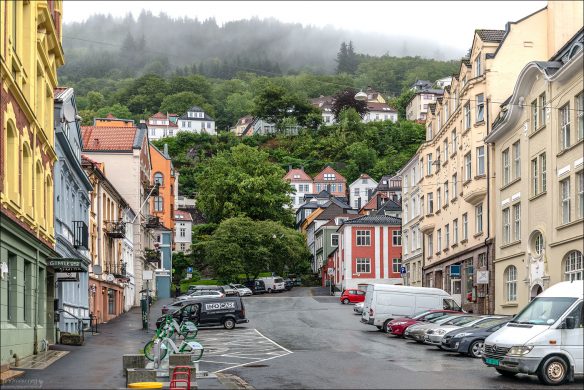 Улица Kong Oscars gate представляет собой смесь деревянных и каменных домов XVIII–XIX веков, с узкими фасадами, характерными для старого Бергена. Первые этажи часто заняты кафе, антикварными лавками, галереями.