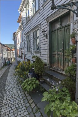 Улица Strangebakken с деревянными домами XIX века, часто в пастельных и охристых тонах.