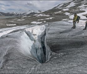 Кревасса с частично обрушенным снежным мостом (snow bridge). Самый опасный вид. Лёд может выглядеть совершенно безобидным, но под тонким слоем снега скрывается пустота. Именно поэтому на леднике не ходят в одиночку — только в связке, где каждый отвечает не только за себя.