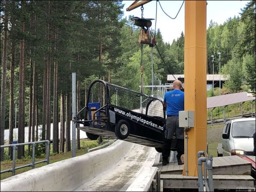 Процесс погрузки колесного боба в желоб с помощью подъемного крана. Этот специальный летний снаряд кардинально отличается от зимнего: он оснащен автомобильными колесами, массивным металлическим каркасом безопасности и защитной сеткой.