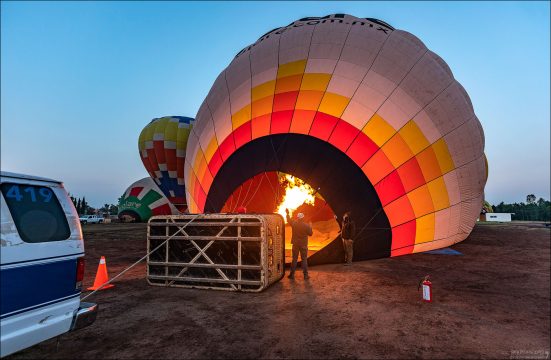Пилот и наземная команда запускают газовую горелку, направляя мощный поток пламени внутрь купола для прогрева воздуха.