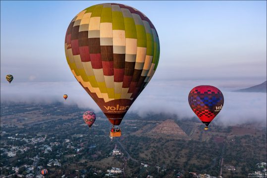 Несколько аэростатов компании Volare идут на разной высоте прямо над историческим комплексом Теотиуакан.
